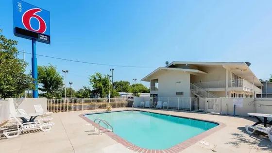 Pool at a hotel with chairs and a building