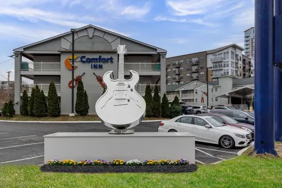 Statue of a guitar in a parking lot