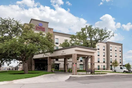 Tan hotel with a Comfort Suites sign and stone canopy