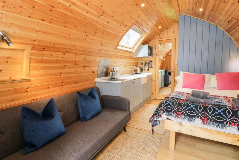 Conwy Pod one room interior with bed bench and kitchenette