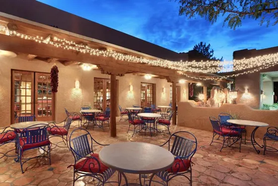 Flagstone patio with red-cushioned chairs under string lights
