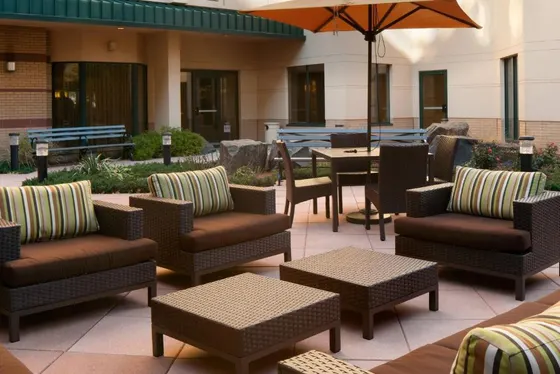 Patio with chairs and tables and an umbrella