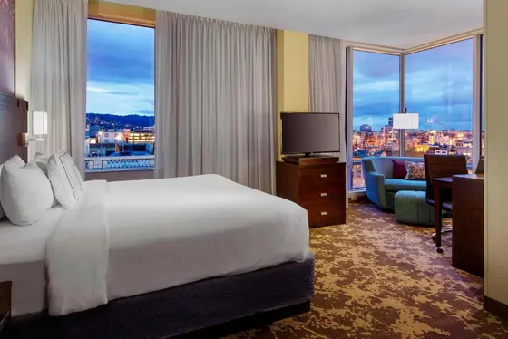 Hotel room with a bed and a view of a city