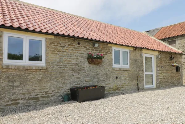 Crabtree Cottage stone barn with red tile roof and gravel courtyard