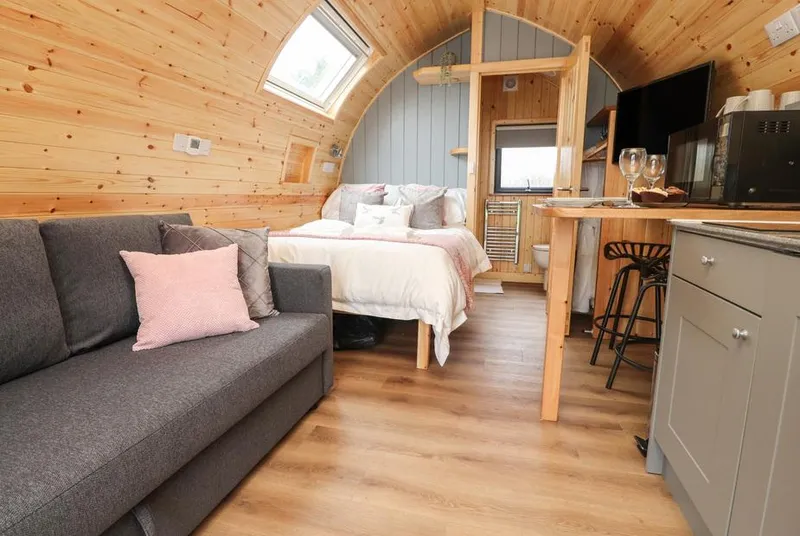 Curlew Corner pod interior with bed, sofa, and kitchenette
