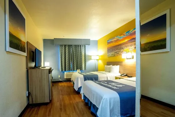 Two beds with blue runners and a yellow accent wall