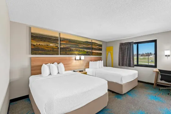 Hotel room with two beds and a desk