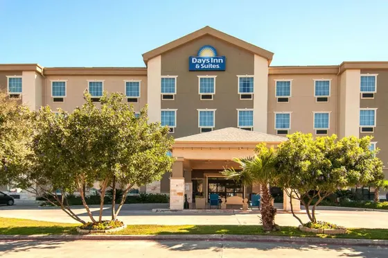 Beige three-story hotel with a yellow sun logo above the entrance