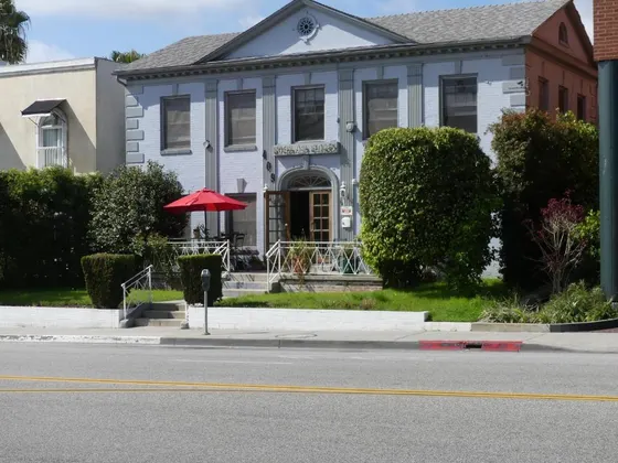 Blue house with a red umbrella in front of it