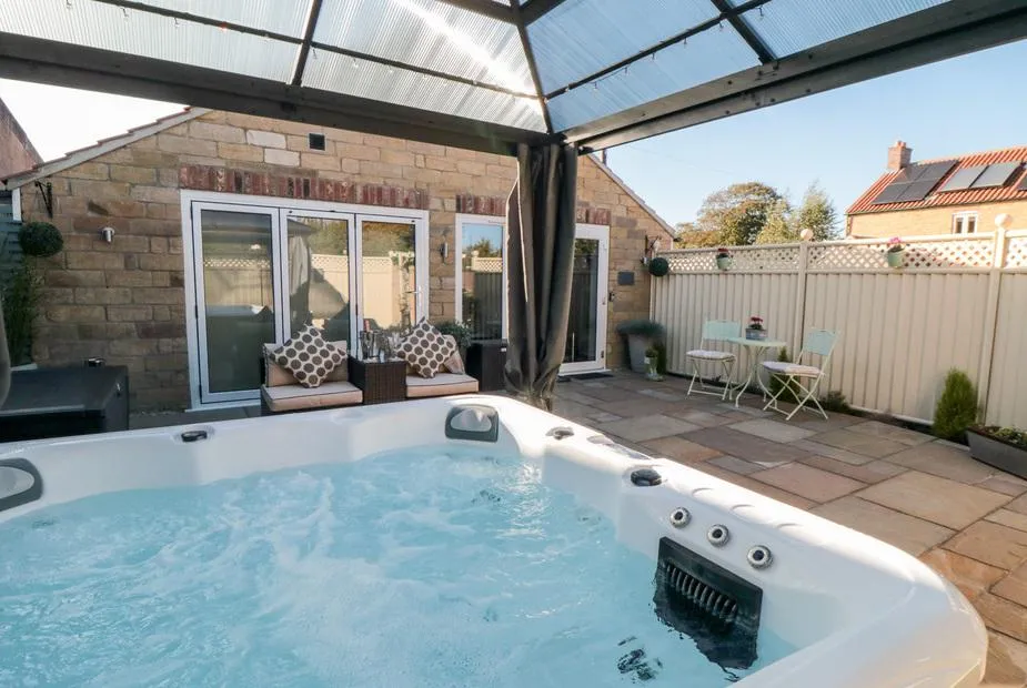 Garthgate Holiday Lodge hot tub under clear gazebo with blue sky
