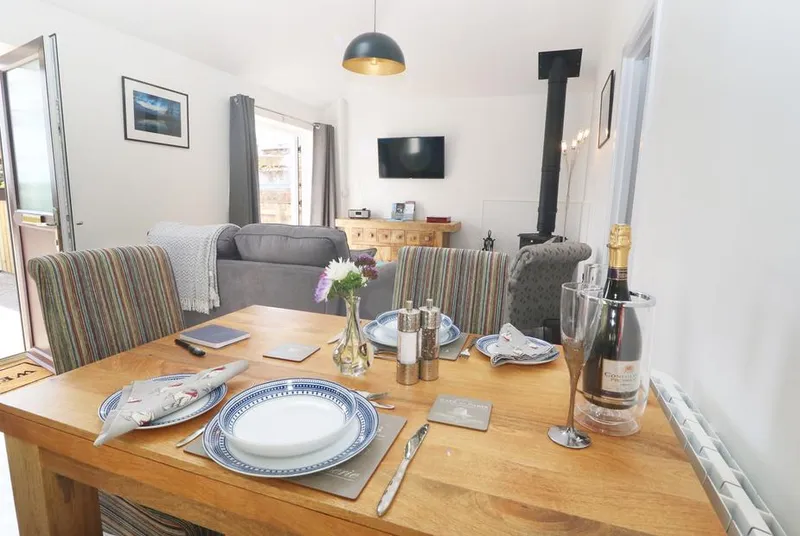 The Old Mill Hideaway dining table with champagne and wood burner
