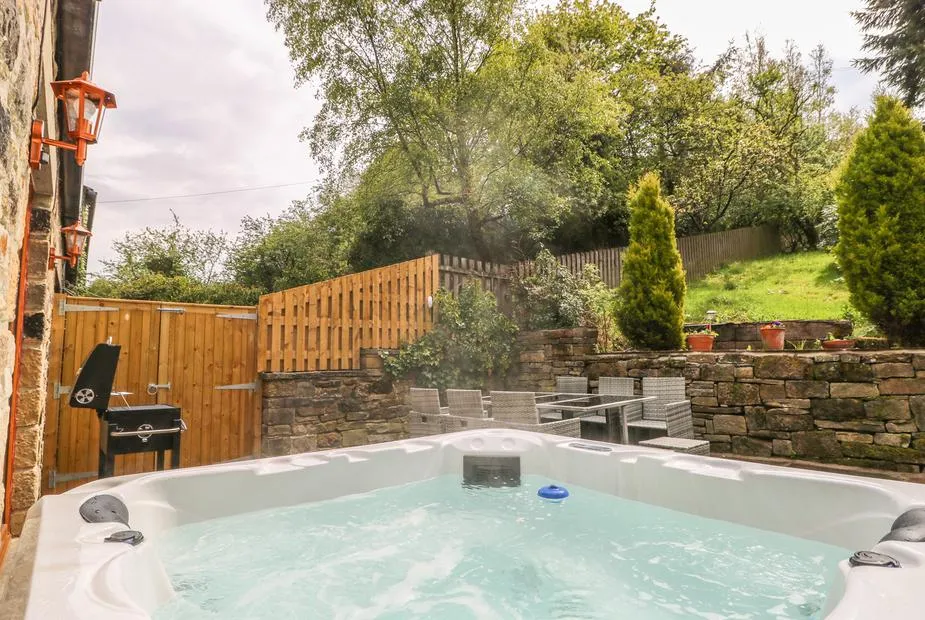 Middle Barn hot tub with lush garden backdrop