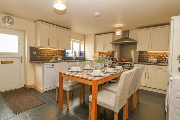 Middle Barn warm kitchen-diner with range cooker and flowers