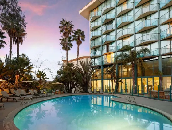 Hotel with a large swimming pool in front of a building