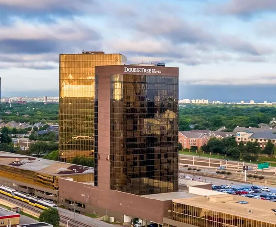 Bronze-glass hotel tower beside a gold reflecting building