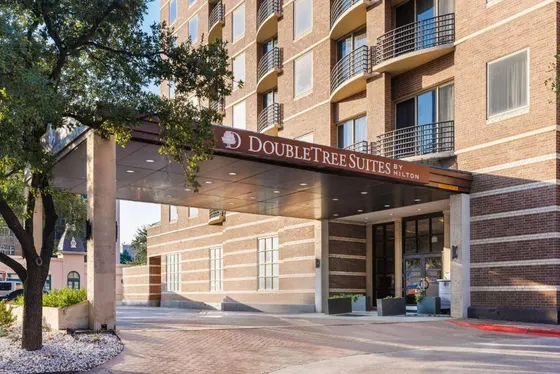 Brick hotel with a DoubleTree Suites by Hilton canopy sign