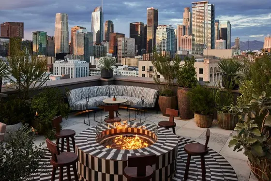 Patio with a fire pit with a view of a city