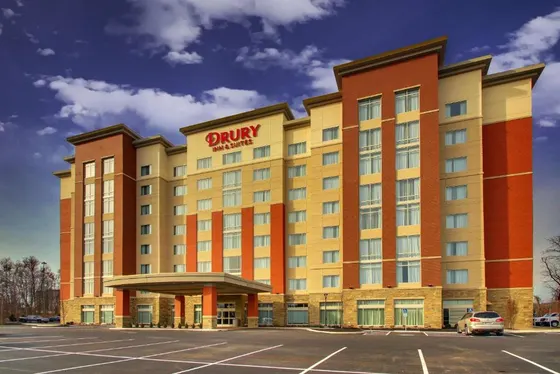 Brick hotel with a circular covered driveway and empty lot