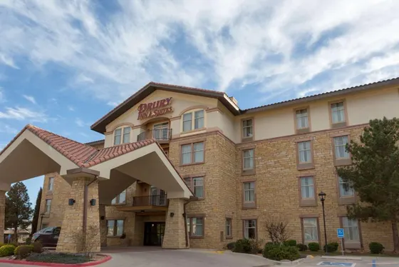 Tan stone hotel with a red tiled roof and Drury Inn sign
