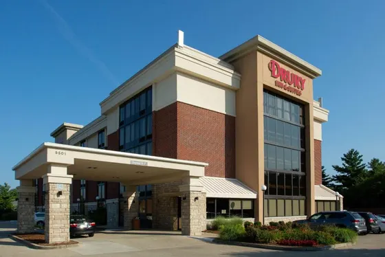 Brick hotel with glass windows and a covered stone entrance
