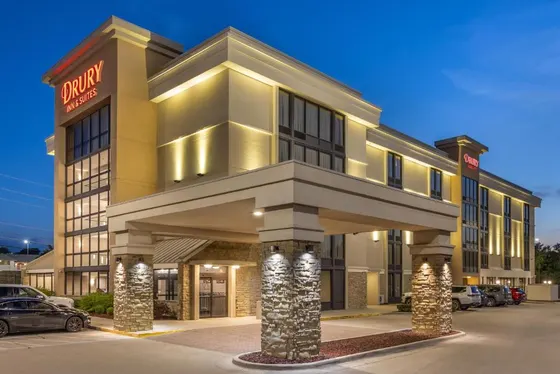 Hotel building with a car parked in a parking lot