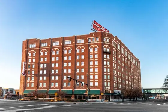 Large red brick building with a street sign on top