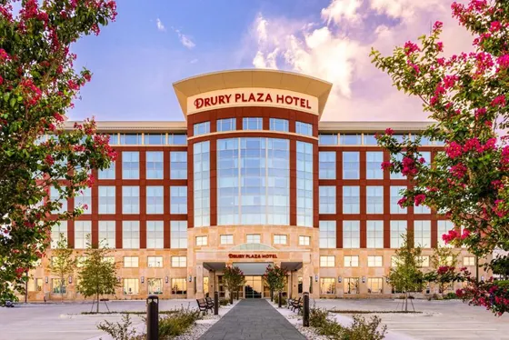 Brick hotel with a curved glass front and a Drury Plaza sign