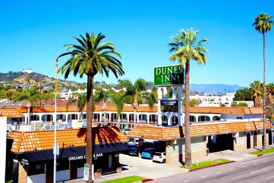 Street sign in front of a building with palm trees