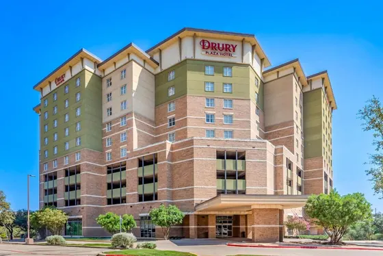 Brick hotel with green upper floors and a Drury Plaza sign