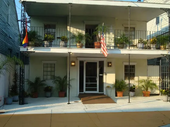 Two-story building with a plant-filled balcony and iron railing