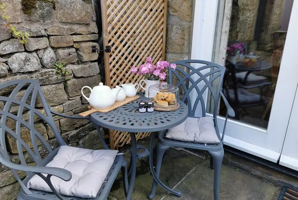 End Cottage private stone courtyard with bistro set and tea