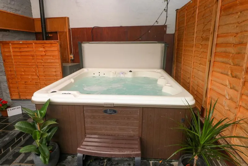 Y Cartws private hot tub in a sheltered courtyard