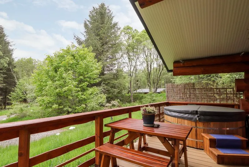 Heron Lodge hot tub on a covered woodland veranda