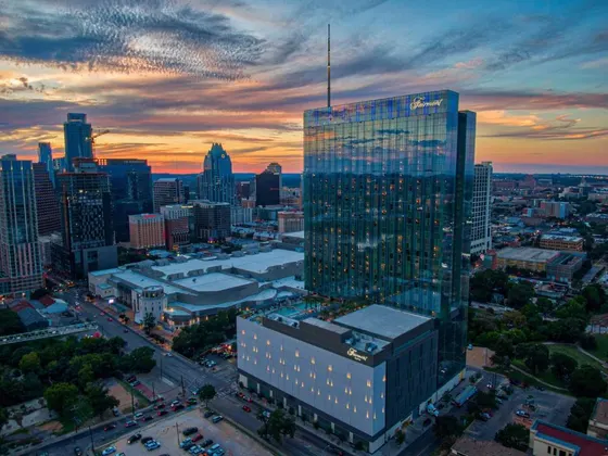 Blue-glass Fairmont tower against an orange sunset sky