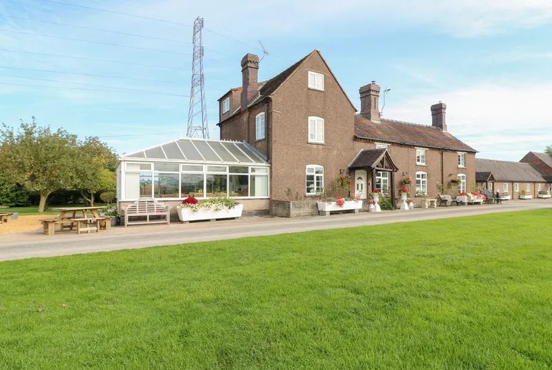 Far Coley Farm brick farmhouse with conservatory and flower planters
