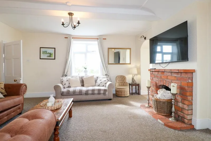 Far Coley Farm living room with red brick fireplace and leather sofas