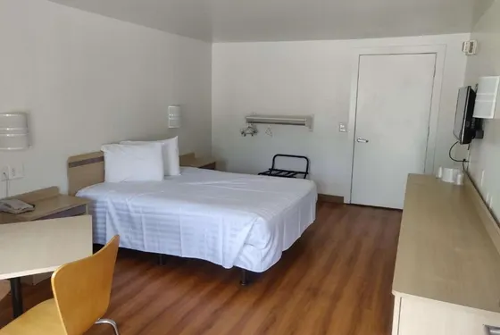 Hotel room with a white bed and a desk