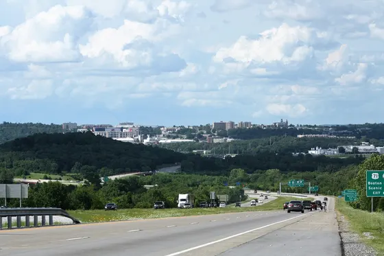 I-49 leading toward the Fayetteville skyline across wooded hills