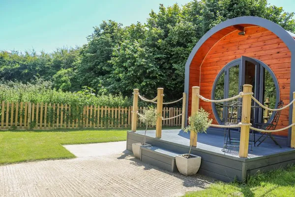 Filbert Pod front view with deck and rope railings in green garden