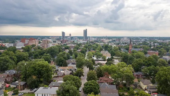 Downtown Fort Wayne skyline over a tree-lined neighborhood