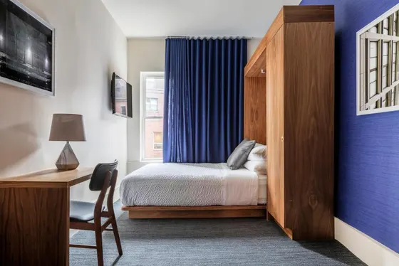 Bedroom with a bed and a desk and a window