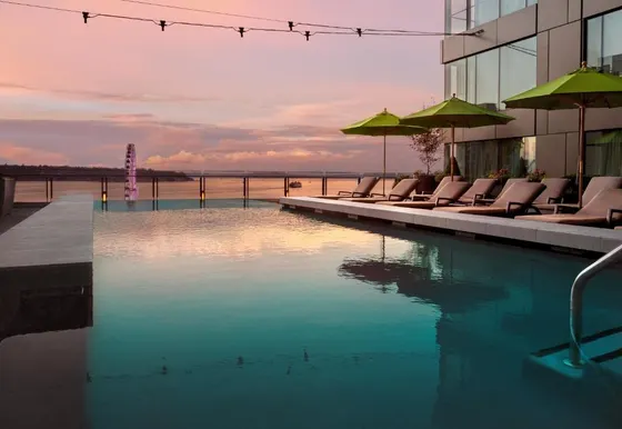 Pool with chairs and umbrellas next to a building