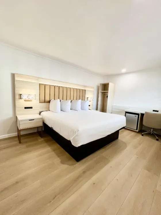 Bedroom with a large white bed and a desk
