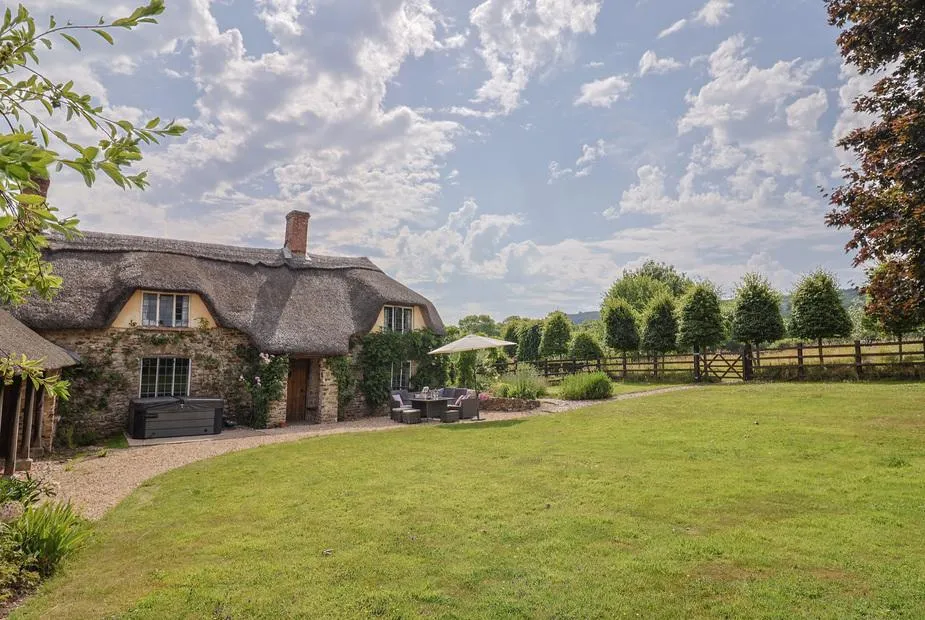 Garden View thatched cottage with hot tub, lawn, and countryside views