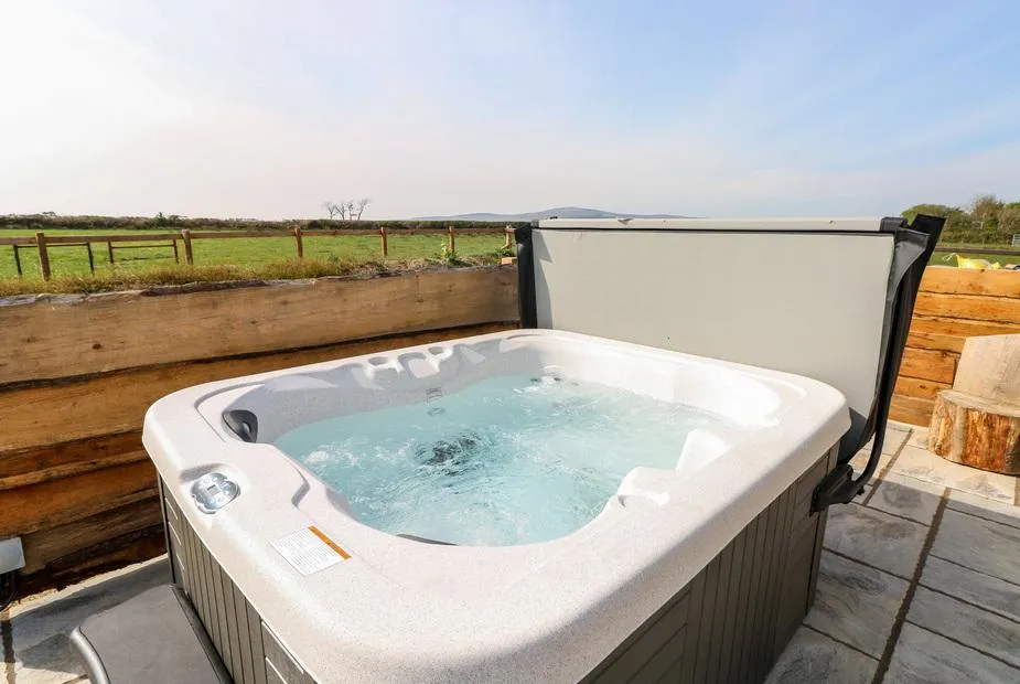Glowty Brynbedw hot tub on the deck with open countryside beyond