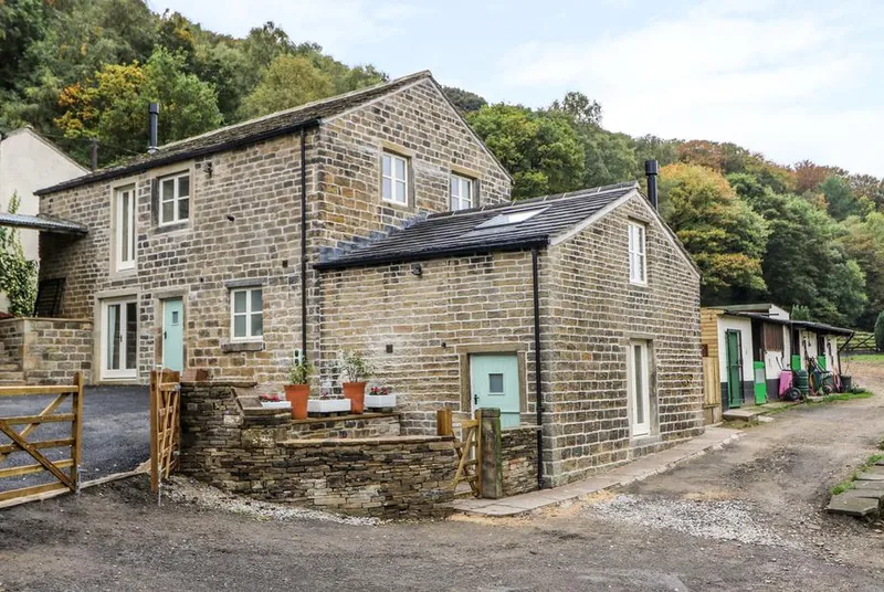 The Stables stone barn conversion with wooded hillside