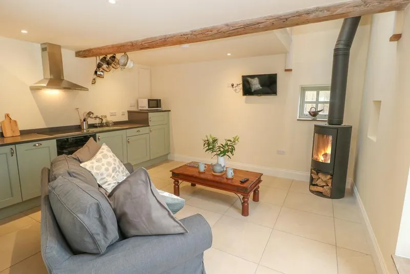 The Stables open-plan living with wood burner and sage kitchen