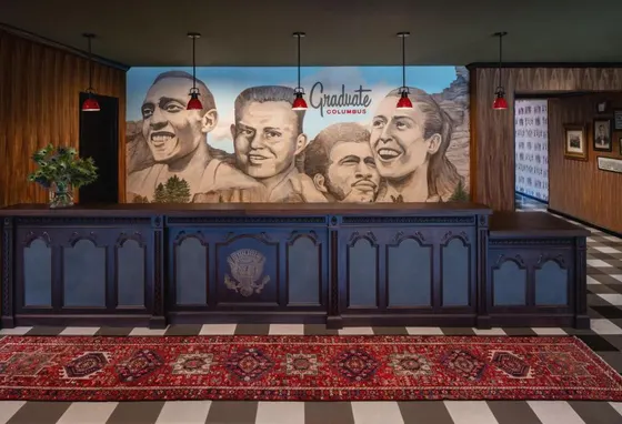 Wood reception desk with a portrait mural and red lamps