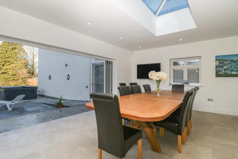 Greenlawns dining room with bi-fold doors open to patio and hot tub visible