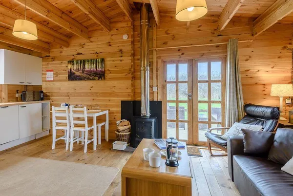 Halfmoon Wood open-plan cabin interior with log burner and dining nook